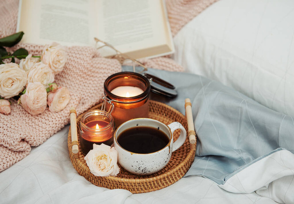 Romantic breakfast in bed. Hygge concept. Tray of coffee and candles on bed. - Photo, Image