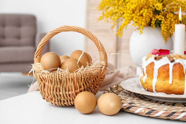 Καλάθι με αυγά και πασχαλινό κέικ στο τραπέζι - Φωτογραφία, εικόνα