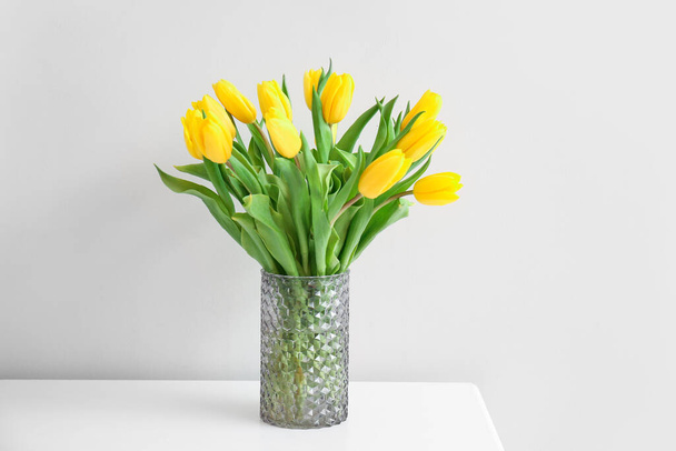Váza gyönyörű tulipánok az asztalon, közel a fény fal - Fotó, kép