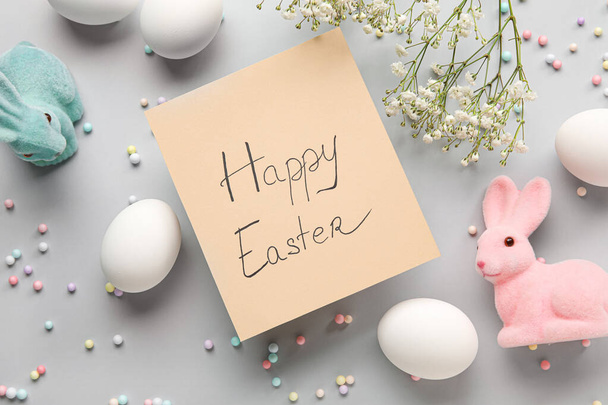 Composición de Pascua con tarjeta de felicitación, flores de gypsophila y huevos sobre fondo claro - Foto, imagen