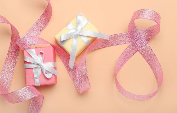 Composition with figure 8 made of ribbon and gift boxes for International Women's Day celebration on beige background - Photo, Image
