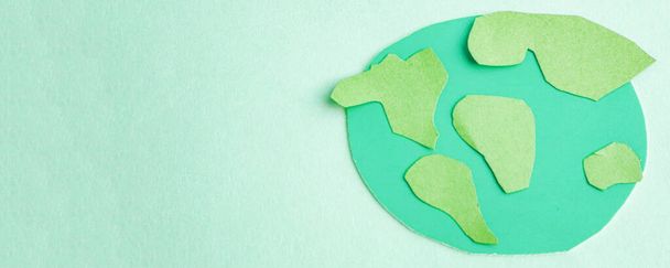 Schattig kinderpapier applique - een model van de aarde op een blauwe achtergrond. Creatief concept Earth Day, Earth Hour, kopieer ruimte voor tekst. - Foto, afbeelding
