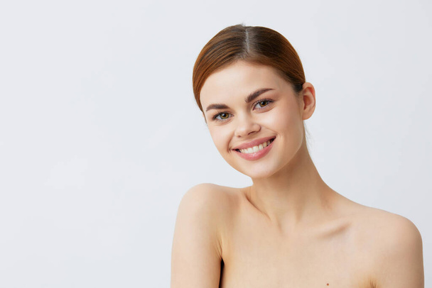 όμορφη γυναίκα χαμογελαστή γυναίκα γυμνοί ώμοι καθαρό δέρμα γοητεία Μοντέλο φως φόντο - Φωτογραφία, εικόνα