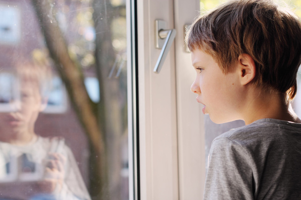 Boy looking through the window - Photo, Image