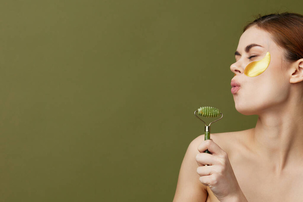 hermosa mujer parches rejuvenecimiento cuidado de la piel diversión después de la ducha masaje facial fondo verde - Foto, Imagen