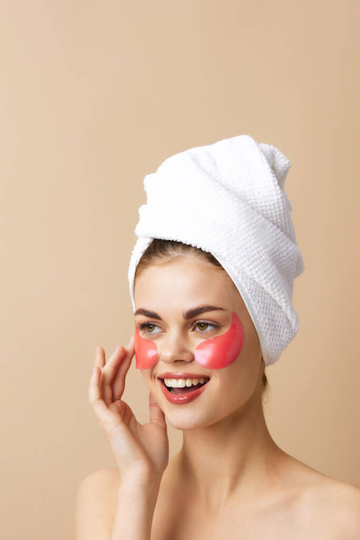 kobieta z ręcznikiem na głowie gestykulując dłońmi skóra pielęgnacja beżowy tło - Zdjęcie, obraz