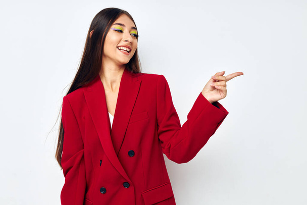 portrait pretty woman in a red jacket cosmetics smile light background unaltered - 写真・画像