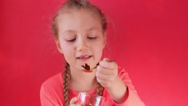 Child eating yogurt jelly pink background. Dairy product diet Lactobacillus Acidophilus, healthy homemade breakfast menu. Kids healthcare. Vegan food nut milk gelatin non-dairy dessert Protein pudding - Footage, Video