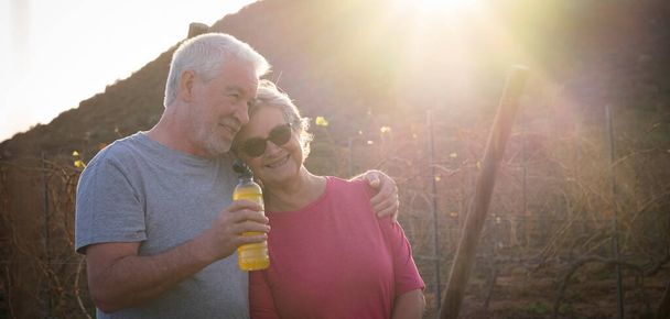 Glückliches altes, reifes Paar Mann und Frau ruhen sich nach gesunden, aktiven Sportübungen im Freien aus. Senioren genießen Gesundheit und Lebensstil, um jung zu bleiben. Konzept der ewigen Liebe - Foto, Bild