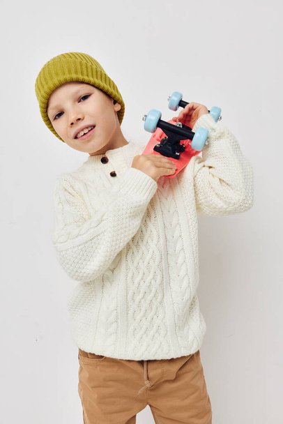 little girl in hats with a skateboard in their hands light background - Φωτογραφία, εικόνα