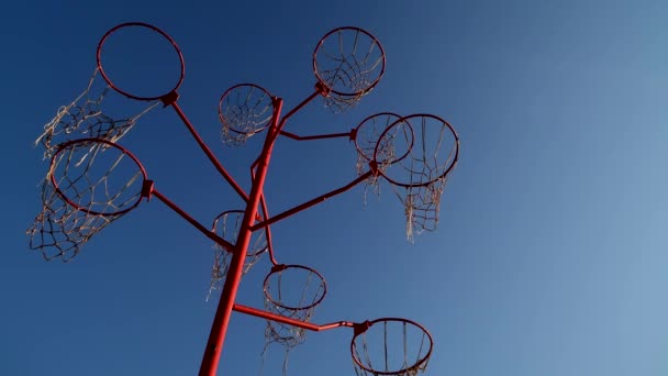 arte objeto de aros de baloncesto desde arriba en movimiento ascendente. No hay personas en covid 19 pandemia, 4k imágenes de alta calidad aisladas en el cielo azul - Metraje, vídeo