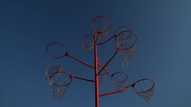 kunst object van basketbal hoepels van boven in stijgende beweging. Geen mensen in covid 19 pandemie, 4k hoge kwaliteit beelden geïsoleerd op blauwe lucht - Video