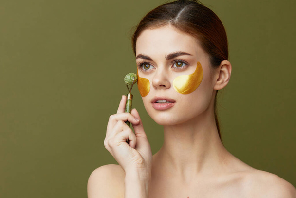 portrait woman face massager golden patches on the face isolated background - Foto, afbeelding