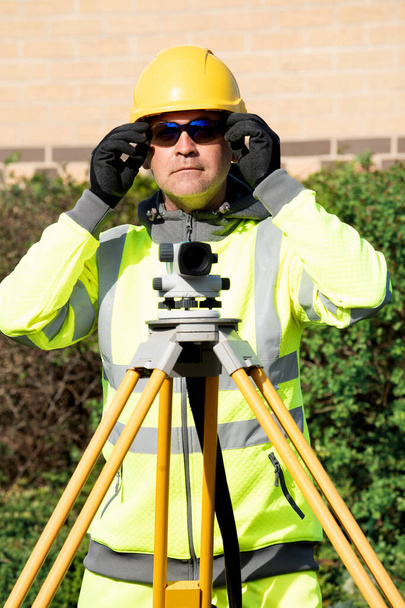 Engenheiro local verificando os níveis da estrada usando autolevel - Foto, Imagem
