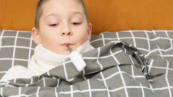 sick boy with a thermometer in his mouth. close-up - Foto, imagen