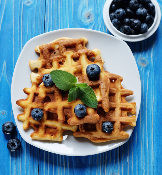 Homemade Belgian waffles served with fresh berries on white plate over wooden background, close up. Top view. Flat lay,Tasty. Sweet. - Zdjęcie, obraz