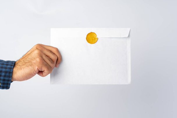 Male hands holding an envelope with a wax seal - Φωτογραφία, εικόνα