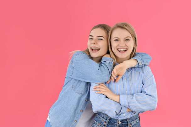 Концепция дружбы с двумя девушками на розовом фоне - Фото, изображение