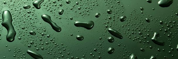 濃い光沢のある表面に緑色の金属水が落ちる - 写真・画像