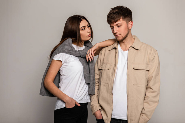 Fashionable beautiful couple girl and boy in stylish casual clothes pose in the studio - Fotografie, Obrázek