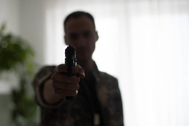 Un soldat de l'armée tire avec un pistolet dans les mains à l'écran. Prendre d'assaut le concept du bâtiment - Photo, image