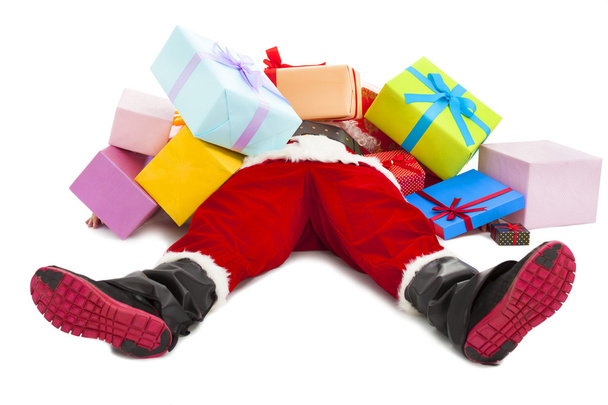 Санта Клаус слишком устал, чтобы лежать на полу со многими подарочными коробками
 - Фото, изображение