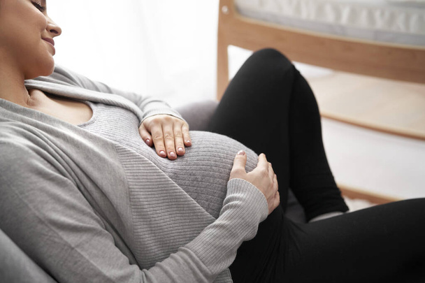 Donna caucasica in gravidanza avanzata sdraiata sulla poltrona e rilassante - Foto, immagini