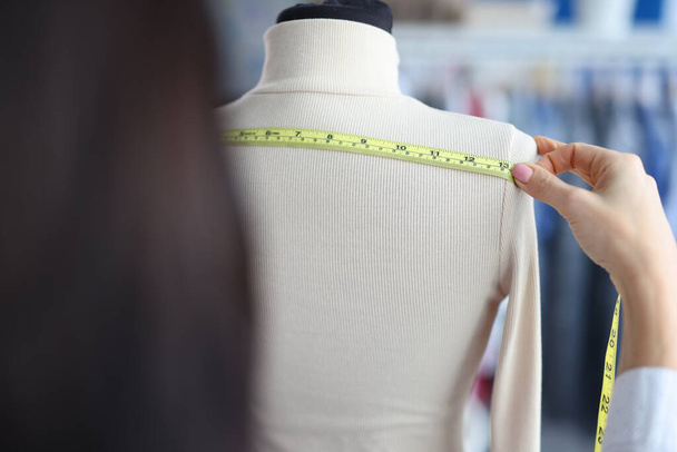A woman measures the width with a tape on a mannequin - Photo, Image