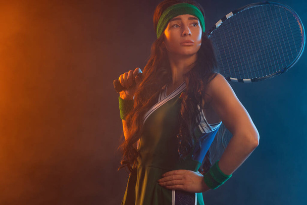 Tennis player with racket in sportswear. Woman athlete playing dark background. - Foto, Imagem