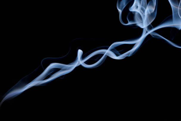 Скрученные пятна дыма, движение дыма на черном фоне. Абстрактные дымовые линии  - Фото, изображение
