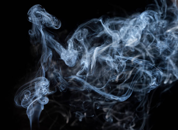 Plumas retorcidas de humo, movimiento de humo sobre un fondo negro. Líneas de humo abstractas  - Foto, Imagen