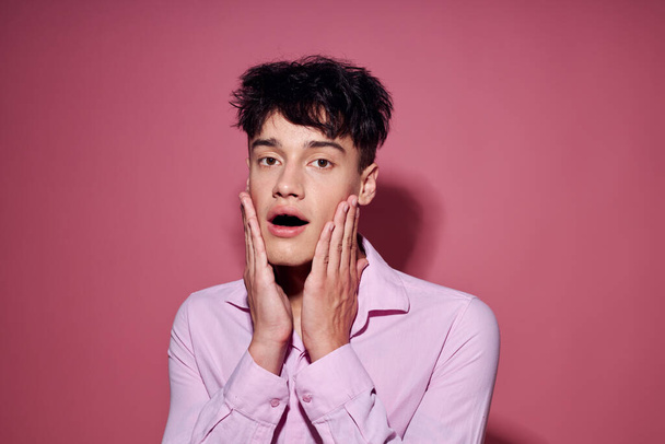 handsome guy gestures with hands emotions hairstyle fashion pink background unaltered - Foto, Bild