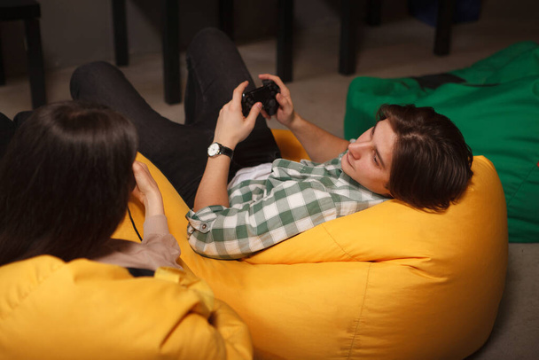 Young man looking at his girlfriend while playing video games together - Valokuva, kuva