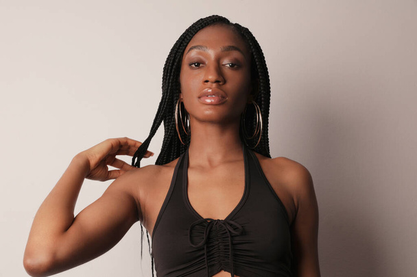 Headshot of serious young afro American woman with shining skin and long braids. - Foto, Imagem