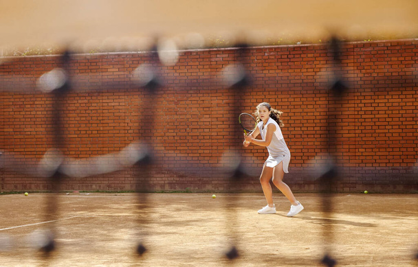 Mladá dívka blokování míč s tenisovou raketou během tréninku - Fotografie, Obrázek