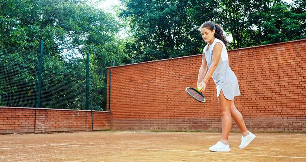 Tennis player practising her serve technique at training - Фото, зображення