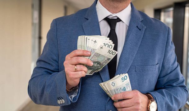 uudet Puolan zloty setelit käsissä liikemies puku. Suurten ja pienten yritysten käsite - Valokuva, kuva