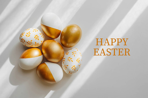 Happy Easter card. Easter golden eggs on on white background. Holiday concept.   - Фото, изображение