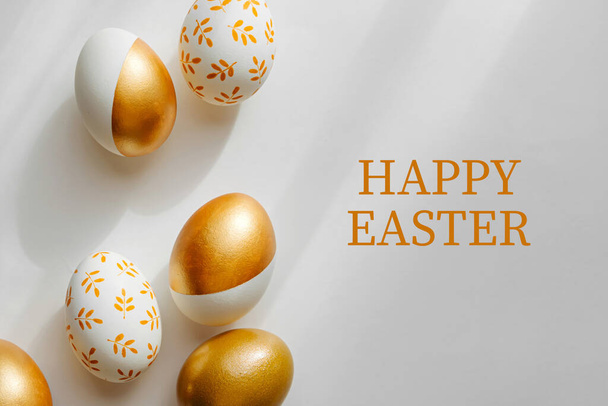 Happy Easter card. Easter golden eggs on on white background. Holiday concept.   - Zdjęcie, obraz