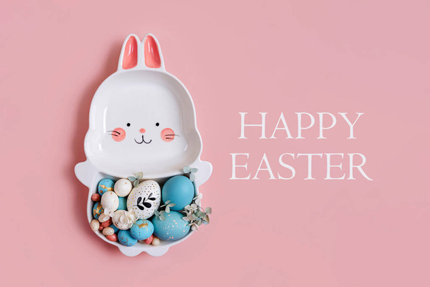 Cute plate in the shape of a bunny with  Easter eggs and candy on pink background. Happy Easter concept.  - Φωτογραφία, εικόνα