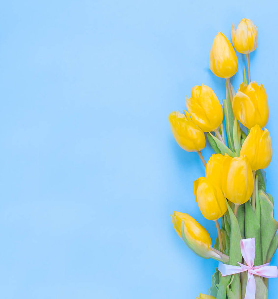 Happy Mothers Day. Yellow Tulip Flowers on Blue Paper Background - Photo, Image