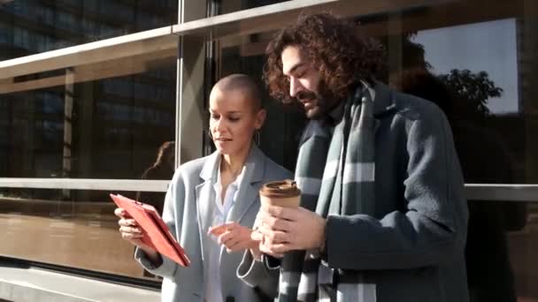 compañeros de trabajo que utilizan una tableta al aire libre en el distrito de negocios en un día soleado - Metraje, vídeo