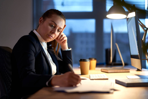 Běloška dospělá žena pracující do pozdních hodin v kanceláři  - Fotografie, Obrázek