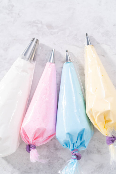 Colorful meringue in piping bags with metal piping tips. - Foto, immagini