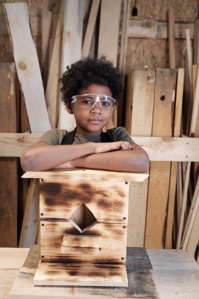Niño negro en taller con pajarera - Foto, Imagen