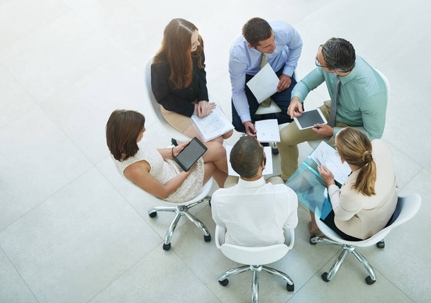Brainstorming leur chemin vers le succès. Plan en grand angle d'un groupe de gens d'affaires réunis dans le bureau. - Photo, image