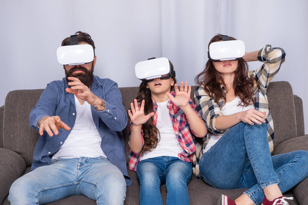 scared family wear vr glasses sitting on sofa at home, virtual reality - Zdjęcie, obraz