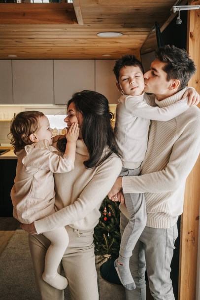 Young happy couple with two children hug and kiss - Photo, image