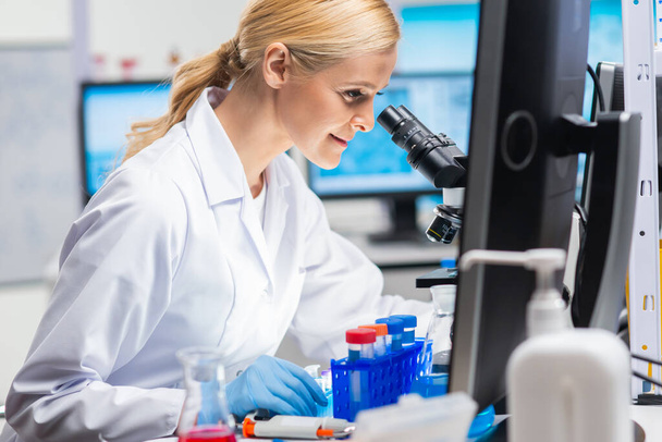 Professional female scientist is working on a vaccine in a modern scientific research laboratory. Genetic engineer workplace. Future technology and science. - Photo, Image
