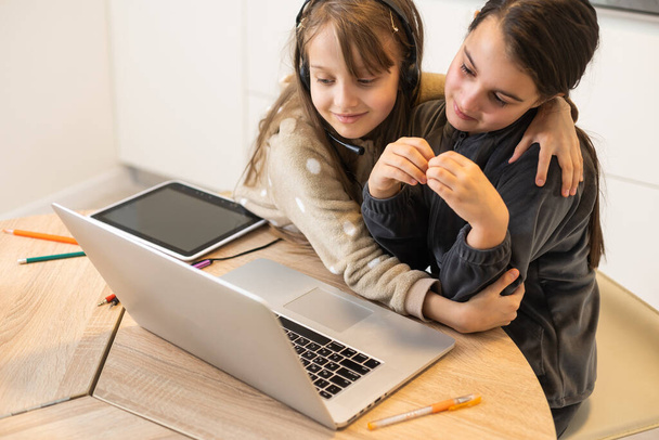 Két gyermek lány diák tanul online tanár videohívással együtt. Testvérek magántanuló számítógép laptop karantén alatt miatt Covid 19 világjárvány. - Fotó, kép